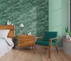 A bedroom scene with a bed, nightstand, and armchair, featuring a marble-patterned wallpaper. Produktbild-Vorschau