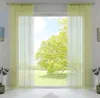A window with light green string curtains, showing a sunny outdoor scene with a large tree. Produktbild-Vorschau