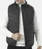 A man wearing a black heated vest over a white sweater. Voir les images du produit