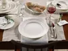 A table setting with plates, cutlery, glasses, and bread. Náhľad obrázku produktu
