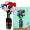 A bouquet of artificial roses in a vase next to its packaging. Náhľad obrázku produktu