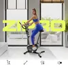 A woman is exercising on a stationary bike in a modern, well-lit room with large windows. Produktbild-Vorschau