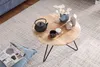 Couchtisch Akazie Massivholz Metall Rund 60x39,5x60cm in Vogelperspektive mit schwarzem Teekessel und Dekorationsobjekten. Voir les images du produit