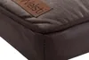 Close-up of the corner of a brown dog bed, showing the texture of the material and a brand tag. Náhľad obrázku produktu