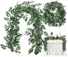 A collage of artificial eucalyptus garlands and a wreath, with one garland draped over a fireplace mantel. Anteprima dell’immagine prodotto