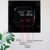 The back of a black electrical thermostat for floor heating is shown, with wiring connections clearly labeled. Voir les images du produit
