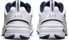 The back view of a pair of white Nike Air Monarch IV sneakers with navy accents. Produktbild-Vorschau