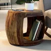 A wooden barrel-shaped side table with books and glasses on top, next to a chair. Podgląd zdjęcia produktu