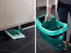 A split image showing a mop cleaning under a cabinet on the left and a person holding a teal mop bucket on the right. Anteprima dell’immagine prodotto