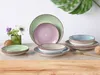 A collection of colorful ceramic plates and bowls arranged on a wooden surface, with a vase of flowers in the background. Náhľad obrázku produktu