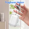 A hand holding keys with an attached transparent headphone case. Produktbild-Vorschau