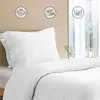 A close-up view of white bedding, including a pillow and duvet, with informational icons in the background. Podgląd zdjęcia produktu