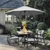 An outdoor patio set with a large umbrella, table, and chairs, set in a garden environment. Produktbild-Vorschau