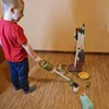 A young boy is playing with a toy cleaning set, including a toy vacuum cleaner and a mop stand. Anteprima dell’immagine prodotto