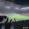 A football stadium with fans cheering and flags waving. Produktbild-Vorschau
