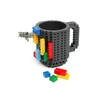 A gray mug with building block attachments and loose building blocks scattered around it. Anteprima dell’immagine prodotto