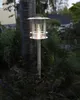 A solar-powered path light is shown in a garden setting, next to a tree trunk and surrounded by plants. Produktbild-Vorschau