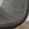 A close-up view of the stitching and texture of a gray leather bar stool. Produktbild-Vorschau