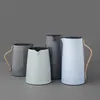 Four thermoses of different colors and sizes are arranged on a gray surface against a gray background. Produktbild-Vorschau