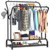A black metal double-rod garment rack with various clothing items and accessories displayed on it, including shirts, pants, shoes, and a hat. Produktbild-Vorschau