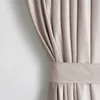 A close-up view of a beige velvet curtain with pleats and a tie-back. Produktbild-Vorschau
