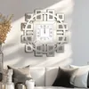 A decorative wall clock with Roman numerals is mounted on a wall above a sofa with pillows. Anteprima dell’immagine prodotto