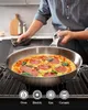 A person is cooking a pizza in a stainless steel pan on a stove. Produktbild-Vorschau