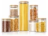 A set of seven glass storage jars filled with different dry goods, arranged on a white background. Produktbild-Vorschau