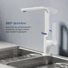 A white kitchen faucet is shown over a double sink with water running. Podgląd zdjęcia produktu