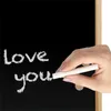 A hand writing 'love you' on a blackboard with chalk. Produktbild-Vorschau