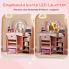 A split image showing a child's pink vanity table and chair, with one side showing the vanity without lights and the other side showing it with colorful LED lights around the mirror. Náhled obrázku produktu