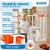 A child and pets interact with a safety gate in a home setting, with marketing text and product details overlaid. Produktbild-Vorschau