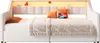 A white daybed with a quilted comforter, two orange pillows, and a tablet on it. There is a shelf above the headboard with decorative items and LED lighting. Voir les images du produit