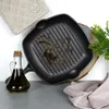 A cast iron grill pan with oil, a bottle of olive oil, and a kitchen pot holder. Produktbild-Vorschau