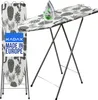 A KADAX ironing board with a cactus pattern is shown, with an iron placed on it. The ironing board is folded and standing upright next to the main ironing board. A blue label with white text is visible on the upright ironing board. Podgląd zdjęcia produktu