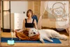 A woman is meditating with her dog in a bedroom, with an essential oil diffuser emitting mist. Produktbild-Vorschau