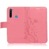 A pink flip case for a smartphone, open to show the inside and the embossed floral pattern on the outer cover. Produktbild-Vorschau
