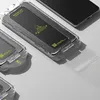 A clear plastic application tool for a screen protector is shown with a phone in the background. Produktbild-Vorschau