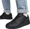A close-up shot of a person wearing black Puma sneakers and light blue jeans. Podgląd zdjęcia produktu