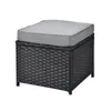A black rattan ottoman with a gray cushion, shown against a white background. Produktbild-Vorschau