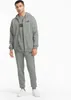A man wearing a grey Puma tracksuit stands against a white background. Produktbild-Vorschau