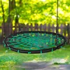 A nest swing hanging in a garden setting with trees and a wooden fence in the background. Voir les images du produit