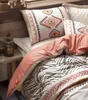 A close-up view of a bed with patterned bedding and pillows. Náhľad obrázku produktu