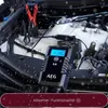 A car battery charger connected to a car engine in a snowy environment. Produktbild-Vorschau