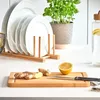 A kitchen counter scene with plates, a cutting board, ginger, lemon, and a water bottle. Anteprima dell’immagine prodotto