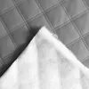 A close-up view of quilted gray material and white padding. Náhled obrázku produktu