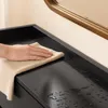 Hand wischt Wasser auf der glänzenden Oberfläche des SoBuy Schuhschranks ab Podgląd zdjęcia produktu