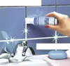 A hand is applying grout sealant to tile grout above a sink faucet. Produktbild-Vorschau