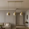 A modern living room with a sofa, a coffee table, and a three-light pendant lamp hanging over a dining table. Produktbild-Vorschau