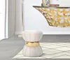 A cream and gold stool is placed on a rug in front of a console table. Produktbild-Vorschau